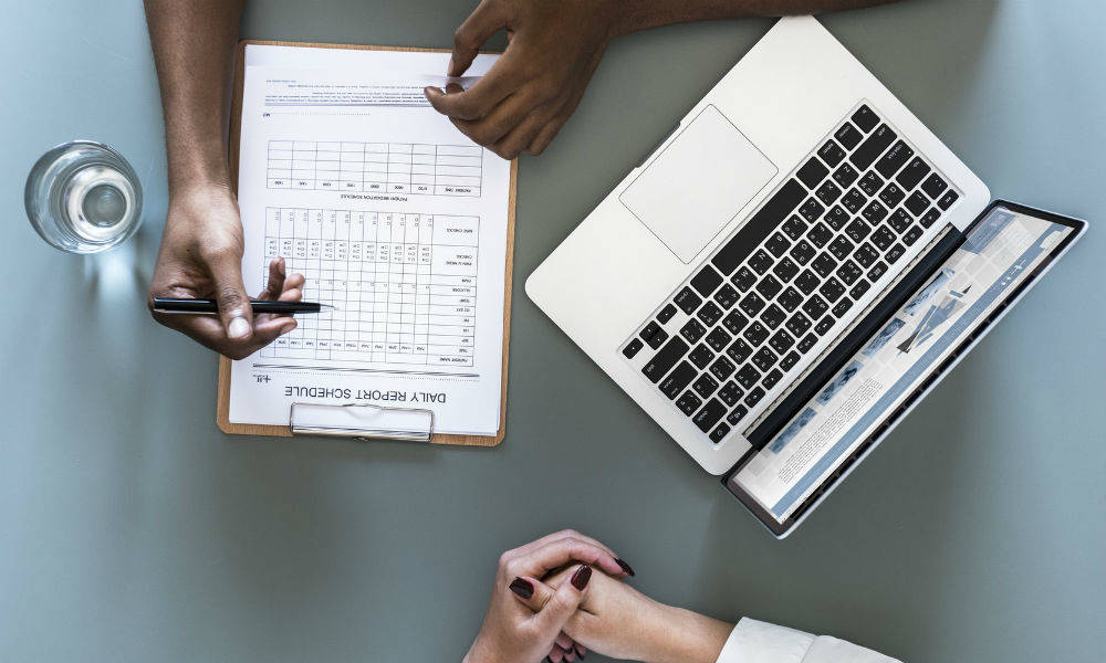 To personer der sidder med en computer og et skema